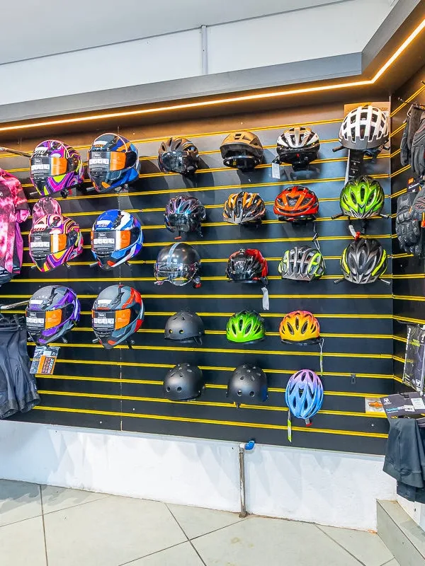Parede de capacetes, luvas e roupas de ciclismo