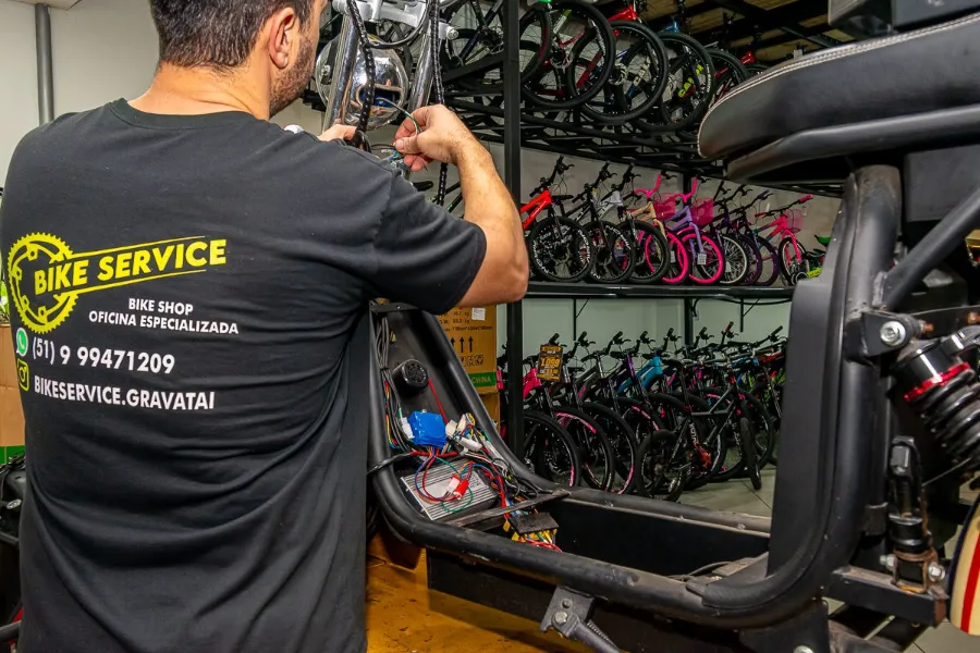 Mecânico da Bike Service consertando a parte elétrica de uma scooter