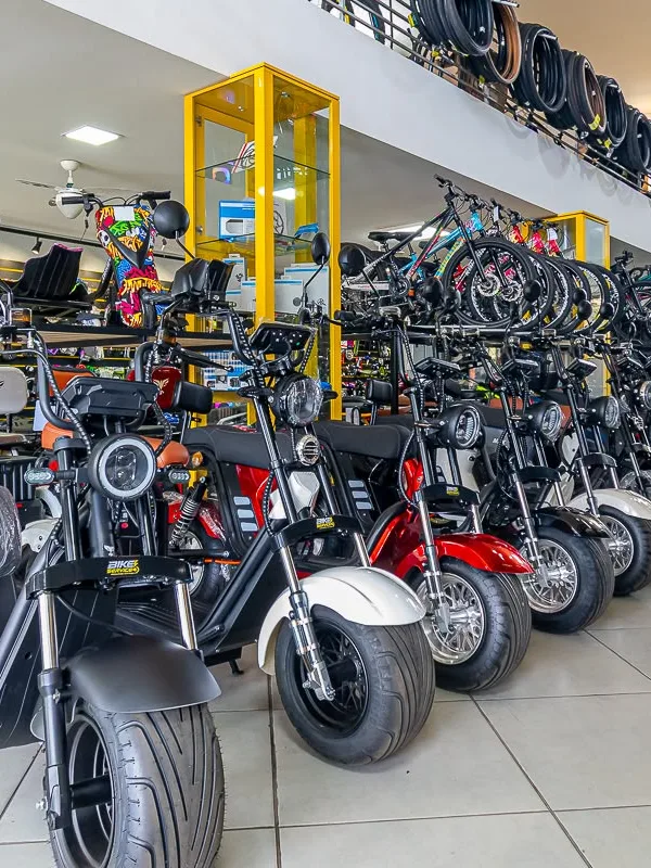 Fileira de scooters elétricas dentro da loja